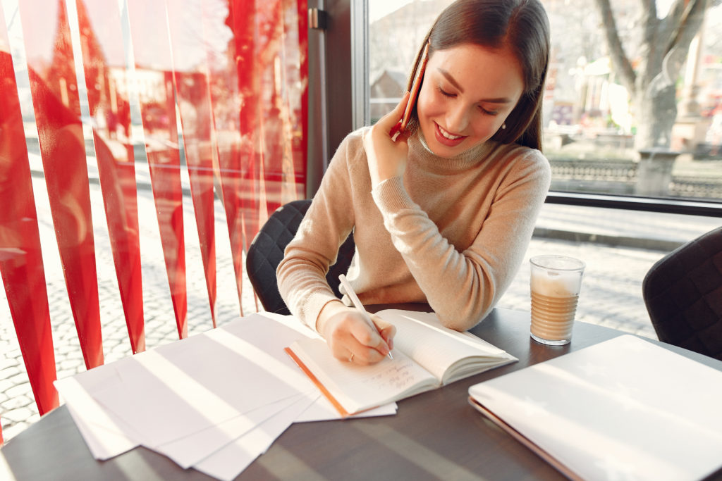 Candidate rédigeant son mémoire DEC à son bureau, concentrée sur sa démonstration écrite